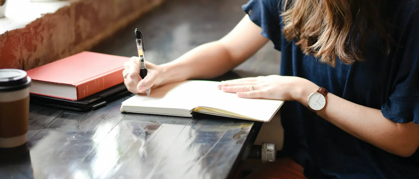 A student writing in a notebook at a desk